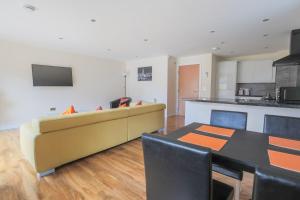 a living room with a couch and a table at Stylish Modern Newly Built Apartment 15 min From City Centre in Edinburgh