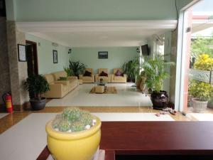 un soggiorno con divani e piante di The Coconut House Hotel a Battambang