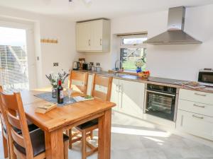 a kitchen with a wooden table and some chairs at Stable View Cottage in Clitheroe