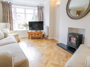 a living room with a fireplace and a tv at 14 Tudno Street in Llandudno