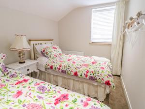 Un dormitorio con dos camas y una ventana. en 14 Tudno Street, en Llandudno