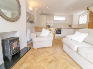 Una sala de estar con un sofá y una estufa de leña. en 14 Tudno Street, en Llandudno 12 fotos más