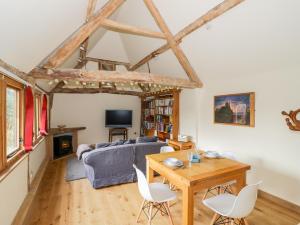 a living room with a couch and a table and chairs at Ryepiece Cottage in Stratford-upon-Avon