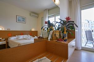 ミラノ・マリッティマにあるHotel Ridolfiのベッドルーム1室(ベッド1台、植物のあるテーブル付)