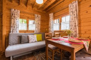 a dining room with a couch and a table at Domki na Leśnej in Sztutowo