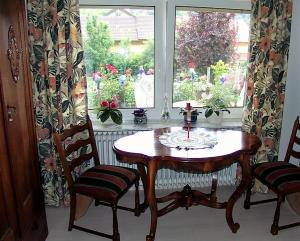 een tafel en 2 stoelen in een kamer met een raam bij Gästehaus Ruländer in Vogtsburg
