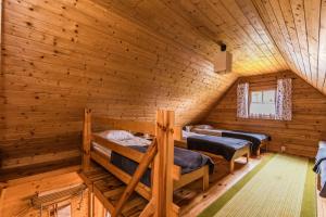 a room with three bunk beds in a log cabin at Domki na Leśnej in Sztutowo