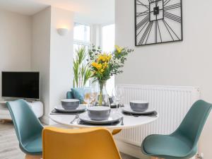 a dining room with a table with chairs and a tv at SeaSound in Ilfracombe