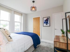 a bedroom with a bed with a blue blanket at SeaSound in Ilfracombe