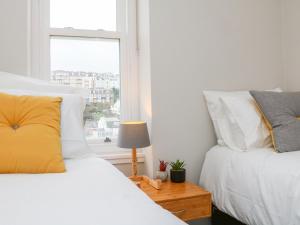 a bedroom with two beds and a window at SeaSound in Ilfracombe