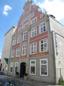 
a large brick building with a clock on the front of it at Haus Wullfcrona in Stralsund
