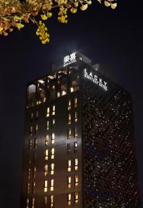 大田的住宿－Hotel Lacky Daejeon，一座高大的建筑,上面有夜间标志