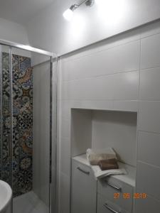 a white bathroom with a shower and a sink at La Casetta di Ninella in Polignano a Mare