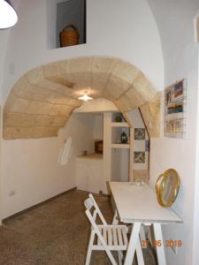 a room with a table and chairs and a stone wall at La Casetta di Ninella in Polignano a Mare