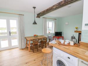 a kitchen and living room with a table and a dining room at Wigrams Canalside Cottage in Southam +12 photos