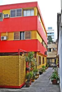 un bâtiment rouge jaune et rouge avec des plantes en pot dans l'établissement La Rojarilla, à San Miguel de Tucumán