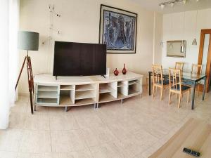 - un salon avec une télévision et une table à manger dans l'établissement tarragonaapartments Fortuny Reus, à Reus