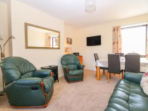 a living room with two chairs and a table at 6 Aonachan Gardens in Spean Bridge