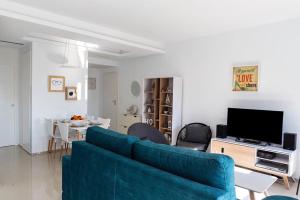 a living room with a blue couch and a tv at Arenales Beach in Arenales del Sol