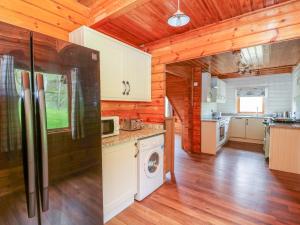 a kitchen with wooden walls and a refrigerator at Pines Pitch in Knighton