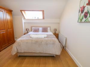 a bedroom with a bed with two towels on it at Llain Haf in Llangefni