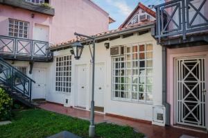 a pink house with white doors and a staircase at Departamento Loft, en medio de la ciudad in Mendoza