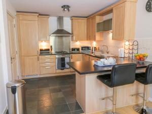 - une cuisine avec des placards en bois et un comptoir dans l'établissement 12 Keathbank Court, à Blairgowrie