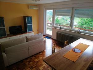 a living room with a white couch and a table at Apartma BAJČI in Ajdovščina