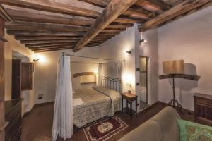 ein Schlafzimmer mit einem Bett und einem Sofa in einem Zimmer in der Unterkunft Relais Santa Cristina in Radda in Chianti