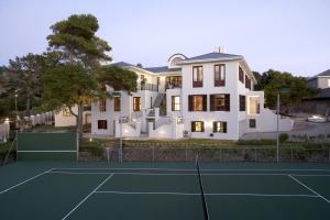 a house with a tennis court in front of it at Nova Constantia Boutique Residence in Cape Town