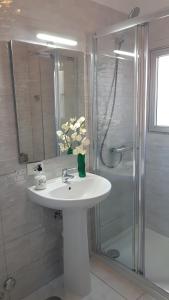 un bagno bianco con lavandino e doccia di Bubu Beach 2-A a Los Cristianos