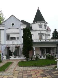 ein großes weißes Haus mit schwarzem Dach in der Unterkunft Vila Kraljica Vrdnik in Vrdnik