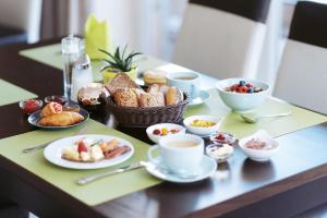 a table with cups of coffee and a tray of pastries at Boutiquehotel Myn Utspann in Husum