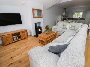 a living room with two couches and a flat screen tv at Mor Awelon in Goodwick