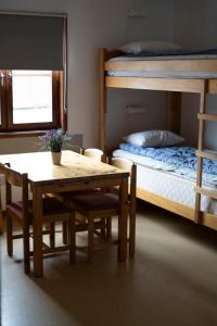 a dining room with a table and a bunk bed at Marsfjäll Mountain Lodge Vandrarhem in Saxnäs