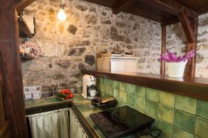 a kitchen with a sink and a stone wall at Slabnik Nature Escape in Idrija