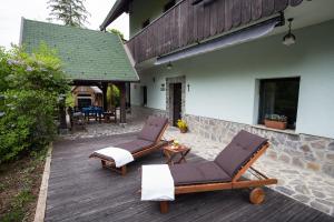 two lounge chairs and a table on a wooden deck at Slabnik Nature Escape in Idrija