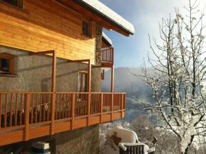 a log cabin with a balcony and a snow covered tree at B&B Alba Sul Lago in Pergine Valsugana