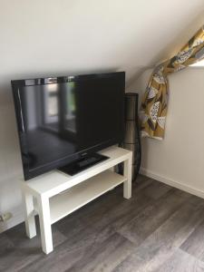 a flat screen tv on a white tv stand at The Tree House in Inverness