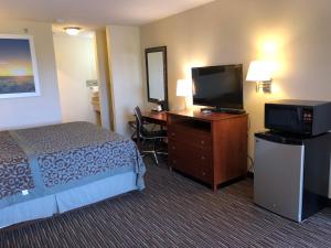 a hotel room with a bed and a flat screen tv at Days Inn by Wyndham Rio Rancho in Rio Rancho