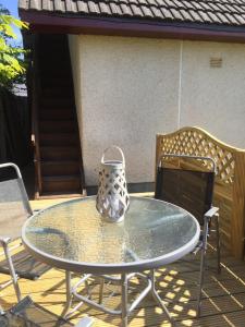 a vase sitting on a glass table on a patio at The Tree House in Inverness +4 photos