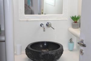 a bathroom with a black bowl sink on a counter at Studios Betty in Plaka Milou
