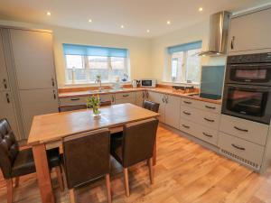 a kitchen with a wooden table and a wooden floor at Runswick in York