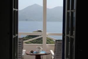 a table and chairs in front of a large window at Studios Betty in Plaka Milou