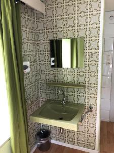 een badkamer met een groene wastafel en een spiegel bij ferienhaus Sundern in Hellefeld