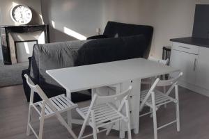 uma mesa branca e cadeiras numa sala de estar com um sofá em Guibert 17 F2 47 m2 Caudebec étage 1 SWEET HOME em Caudebec-lès-Elbeuf