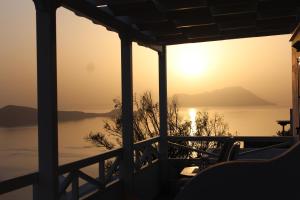 a view of the sunset from the porch of a house at Studios Betty in Plaka Milou