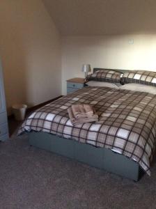 a bedroom with a bed with a blanket on it at Cliff Cottage in Kyle of Lochalsh