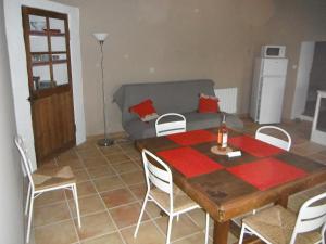 a living room with a table and chairs and a couch at Le Temps d'un Rêve in Mazan