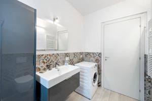 a bathroom with a sink and a washing machine at Casa Bella in Argegno +37 photos